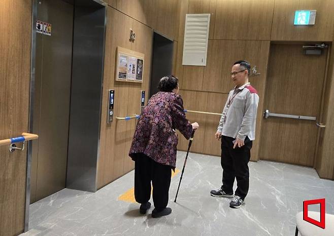서울 송파구 '위례 심포니아' 엘리베이터홀에서 직원이 입주민과 이야기를 나누고 있다. 벽면에는 입주민들이 이동 중 몸을 지탱할 수 있도록 안전 손잡이가 설치돼 있다. 최서윤 기자
