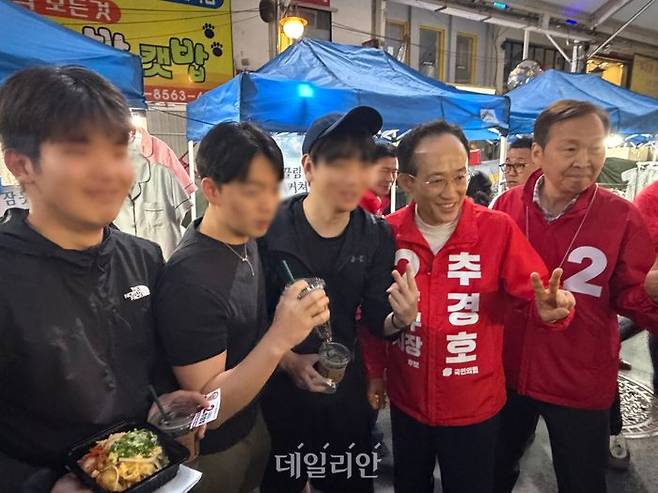 추경호 국민의힘 대구시장 후보와 김기웅 국민의힘 의원이 23일 오후 대구 중구 서문시장 야시장에서 청년들의 사진 요청에 응하고 있다. ⓒ데일리안 김수현 기자