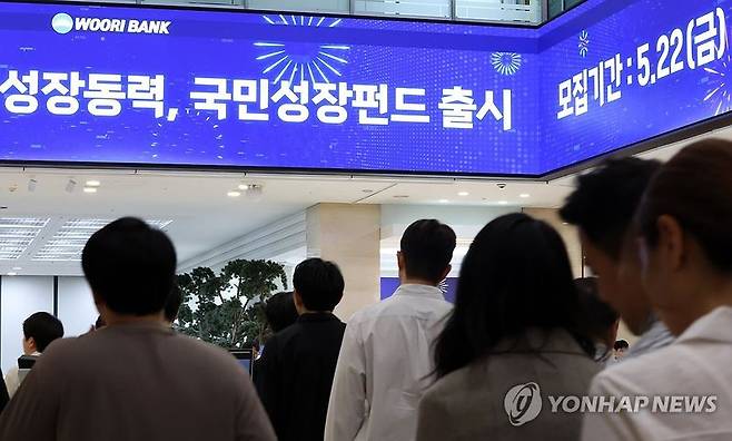 지난 22일 우리은행 한 영업점에 국민참여성장펀드에 가입하려는 고객들이 내방해 긴 줄을 서고 있다. 연합뉴스