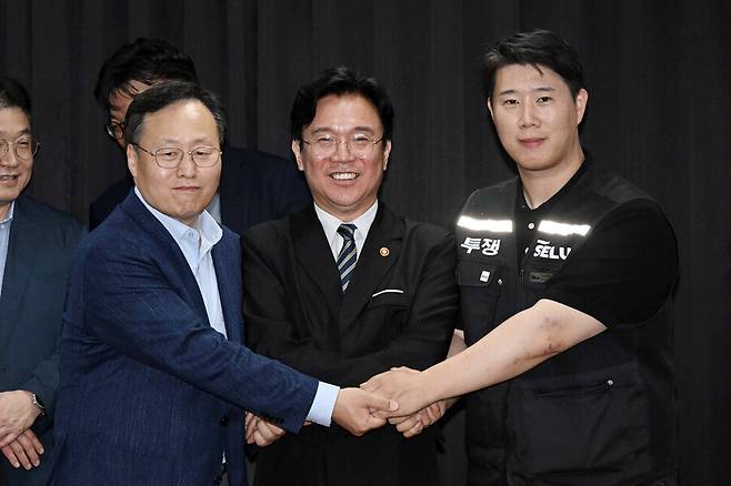 삼성전자 노사 협상이 잠정 합의된 지난 20일 경기도 수원시 장안구 경기지방고용노동청에서 김영훈 고용노동부 장관(앞줄 가운데), 최승호 삼성전자 노조 공동투쟁본부 위원장(오른쪽), 여명구 DS(디바이스솔루션·반도체 사업 담당) 피플팀장이 손을 맞잡고 있다. 이날 삼성전자 노사는 김영훈 장관의 중재로 다시 임금 협상에 나섰다. 공동취재사진