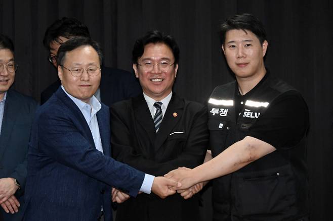 삼성전자 노사 협상이 잠정 합의된 지난 20일 경기도 수원시 장안구 경기지방고용노동청에서 김영훈 고용노동부 장관(가운데), 최승호 삼성전자 노조 공동투쟁본부 위원장(오른쪽), 여명구 DS(디바이스솔루션·반도체 사업 담당) 피플팀장이 손을 맞잡고 있다. /사진=뉴시스(공동취재)