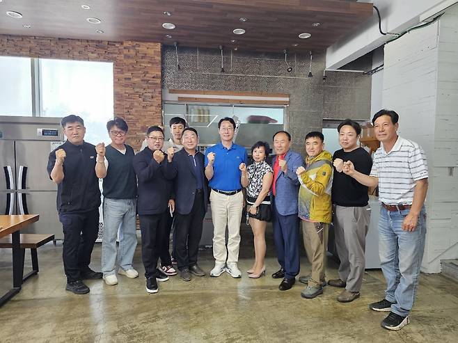 정명근 민주당 화성시장 후보(가운데)가 24일 뱃놀이 축제 현장을 방문해 주민들과 파이팅을 외치고 있다. 정명근 캠프 제공