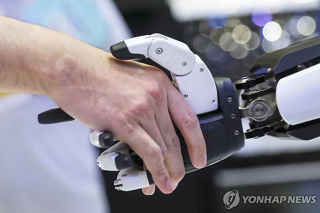 사람과 로봇의 악수 [EPA 연합뉴스 자료사진. 재판매 및 DB 금지]