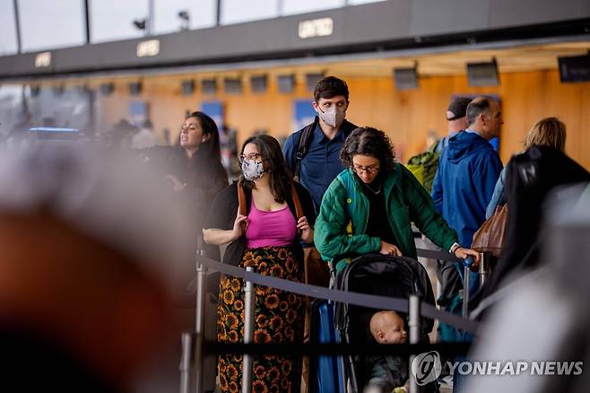 워싱턴덜레스국제공항서 마스크를 쓰고 이동중인 여행객들 [AFP=연합뉴스. 재판매 및 DB 금지]