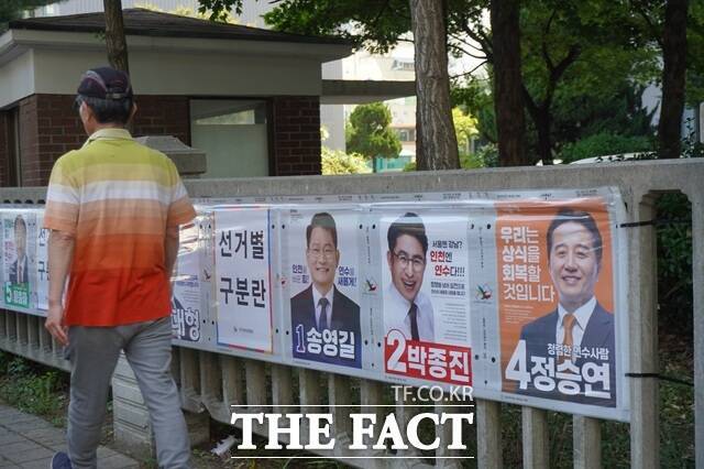 인천 연수구 옥련시장 인근에 걸린 연수갑 국회의원 보궐선거 후보자 벽보. 한 유권자가 벽보를 훑어본 뒤 이동하고 있다. /인천=이태훈 기자
