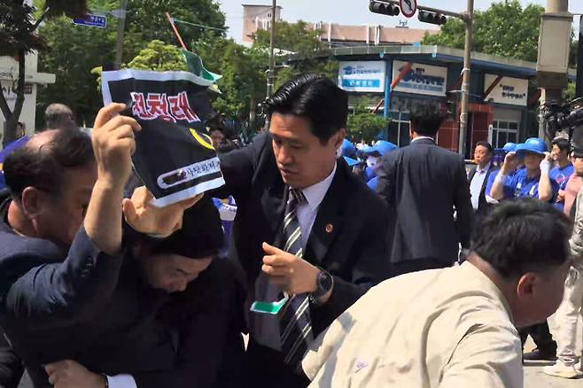 '정청래사당화저지범도민대책위'의 한 회원이 이날 유세차 앞에서 "정청래 아웃"을 외치다 민주당 사설 경호원에 의해 저지당하고 있다. 송승민 기자