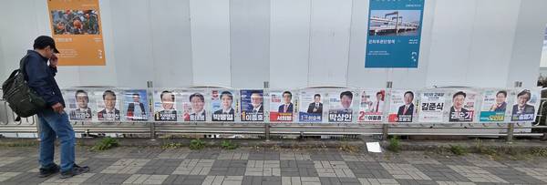 26일 한 시민이 김해시 불암동 사거리에 설치되어 있는 지방선거 후보들의 벽보를 살펴보고 있다./김구연 기자