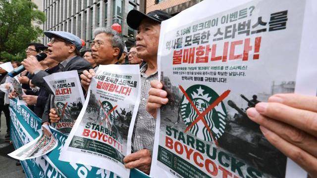 지난 21일 서울 종로구 스타벅스 광화문점 앞에서 5공피해자단체연합회, 국가폭력피해범국민연대, 박종철기념사업회 등 국가폭력 피해자 단체 주최로 열린 기자회견에서 한 참석자가 스타벅스 코리아의 5·18 민주화운동기념일 '탱크 데이' 프로모션을 규탄하며 스타벅스 불매 손팻말을 들고 있다. [사진=연합뉴스]