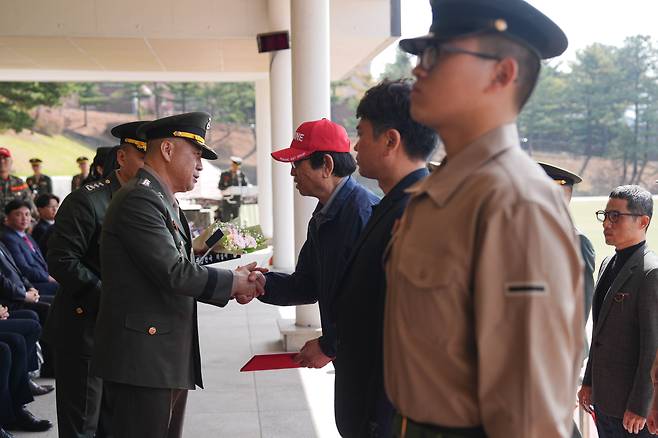 지난 4월 15일 경기 화성시 해병대사령부 행사연병장에서 열린 해병대 창설 77주년 기념 행사에서 주일석 사령관이 해병대 최초 4대 해병 가문에 병역 명문가 패를 전달하고 있다. /해병대사령부