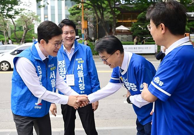 더불어민주당 정원오 서울시장 후보가 26일 서울 영등포구 여의도역 5번 출구에서 선거운동원과 악수하고 있다. 연합뉴스