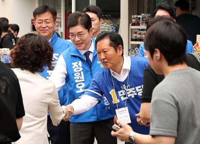 정청래 더불어민주당 대표(오른쪽)와 정원오 서울시장 후보(오른쪽 둘째)가 26일 서울 영등포구 여의도역 5번 출구 앞에서 출근길 시민들에게 인사하며 지지를 호소하고 있다. 공동취재사진