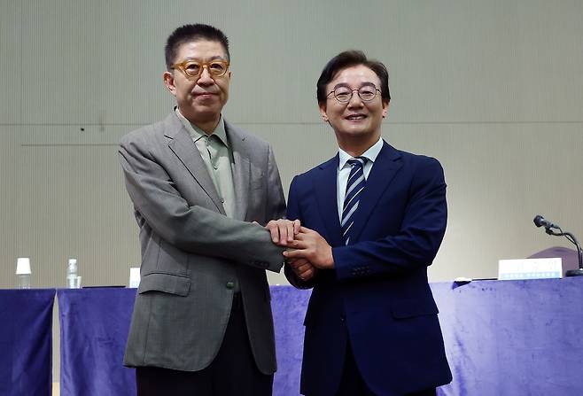 전재수 더불어민주당 부산시장 후보와 박형준 국민의힘 부산시장 후보가 26일 오전 부산 해운대구 동서대학교 센텀캠퍼스에서 열린 관훈클럽·부산일보 주최 관훈토론회에서 손을 맞잡고 있다. 연합뉴스