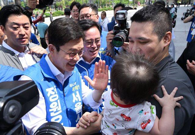 정원오(왼쪽) 더불어민주당 서울시장 후보가 25일 강서구 마곡나루역 앞에서 유권자들과 인사를 나누고 있다. 정 후보는 영등포구 신길2구역도 방문해 “빠르고 안전한 재개발·재건축을 해내겠다”고 강조했다. 이병주 기자