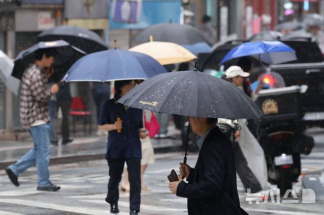 [서울=뉴시스] 권창회 기자 = 지난 20일 서울 중구 서울시청 인근에서 우산을 쓴 시민들이 우산을 쓰고 이동하고 있다. 2026.05.26. kch0523@newsis.com
