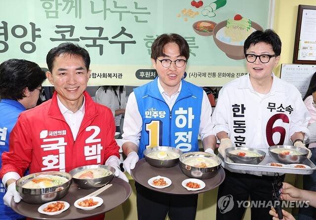 국민의힘 박민식(왼쪽부터), 더불어민주당 하정우, 무소속 한동훈 부산 북구갑 국회의원 보궐선거 후보가 21일 부산 북구 남산정종합사회복지관에서 열린 콩국수 나눔 행사에 참석해 콩국수 배식 봉사를 하고 있다. 연합뉴스