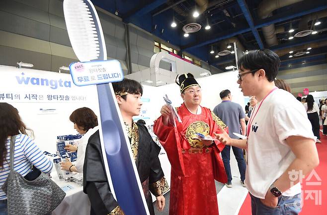 27일 서울 강남구 코엑스에서 막을 올린 2026 코스모뷰티서울(제40회 서울국제화장품·미용산업박람회)에서 왕타 부스 관계자가 왕 복장을 입고 관람객에게 대형 칫솔 설명을 하고 있다./ 이호형 기자 leemario@sporbiz.co.kr 2026.05.27