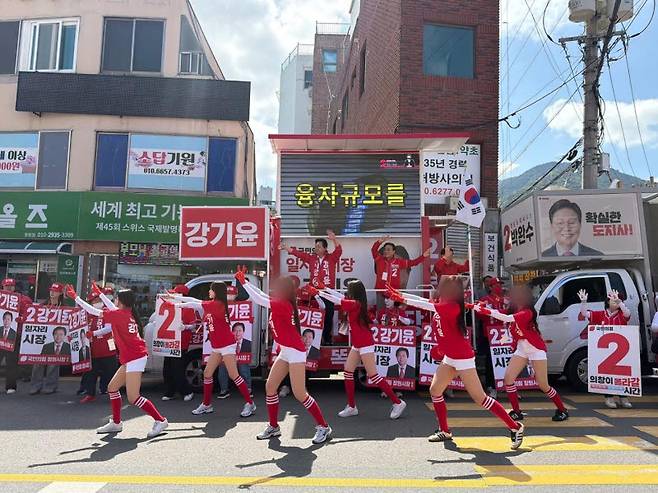 강기윤(유세차량 위 왼쪽) 국민의힘 경남 창원시장 후보 캠프가 23일 창원시 의창구 거리에서 반바지를 입은 여성 선거운동원들과 함께 유세 활동을 하고 있다. (사진=강 후보 페이스북 캡처 이미지).