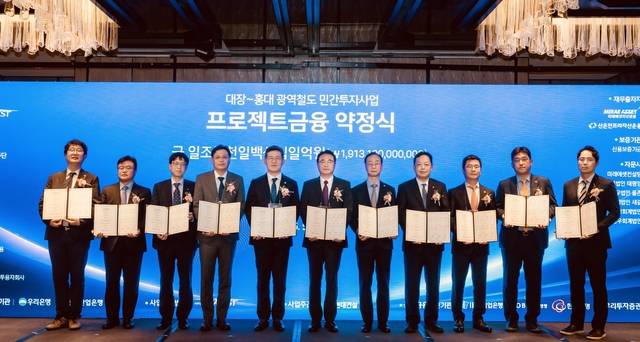 이형락(왼쪽부터) 우리투자증권 전무, 조일연 현대로템 본부장, 이동현 기업은행 부장, 박정범 교보생명보험 본부장, 이명수 우리은행 IB그룹장, 이정한 서부광역메트로 대표이사, 이동훈 현대건설 사업부장, 김연식 한국산업은행 실장, 김선녕 한화생명보험 전무, 김방현 미래에셋자산운용 대표, 손진영 산은인프라자산운용 본부장이 지난 26일 서울 포시즌스호텔에서 금융약정을 체결한 뒤 기념촬영을 하고 있다. [우리투자증권 제공]