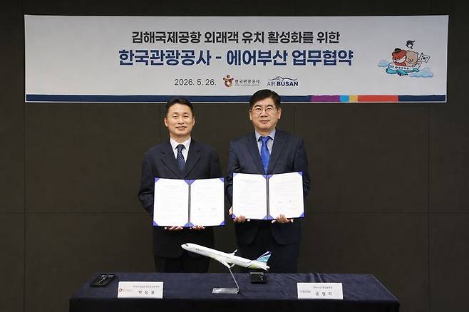 박정웅 한국관광공사 국민관광본부장(왼쪽)과 송명익 에어부산 영업본부장이 김해국제공항 외국인 관광객 유치 확대 및 지역관광 활성화를 위한 업무협약을 체결한 후 기념촬영을 하고 있다. 한국관광공사 제공