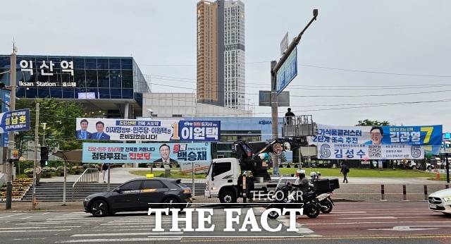 6·3 지방선거를 일주일 앞둔 27일 <더팩트>가 찾은 전북특별자치도에서는 민주당 지지세가 여전히 유지되는 가운데 후보 개인에 대한 평가는 엇갈리는 분위기가 감지됐다. 사진은 익산역 앞에 걸린 지방선거 후보들의 현수막. /익산=서다빈 기자