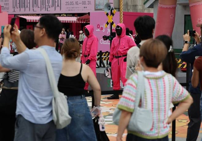 지난해 6월30일 서울 광화문광장에서 2025 K콘텐츠 서울여행주간을 맞아 열린 오징어게임 팝업 광화문 행사에서 시민과 외국인 관광객들이 게임을 즐기고 있다. 연합뉴스