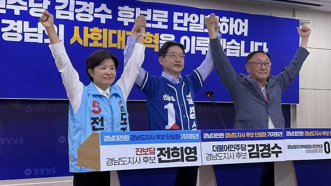 6·3지방선거 경남지사 선거에 출마한 전희영 진보당 후보(왼쪽)와 김경수 더불어민주당 후보(가운데)가 27일 경남도청 프레스센터에서 단일화 발표 전 기념사진을 촬영하고 있다. 뉴스1