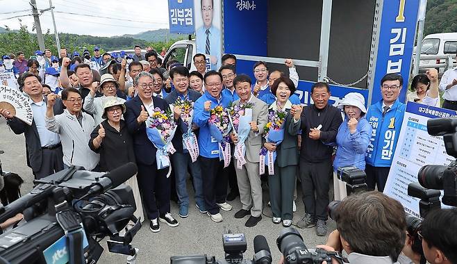더불어민주당 한병도 원내대표와 김부겸 대구시장 후보가 28일 대구 군위군 대구경북신공항 부지를 찾아 파이팅을 외치며 기념 촬영을 하고 있다. 연합뉴스