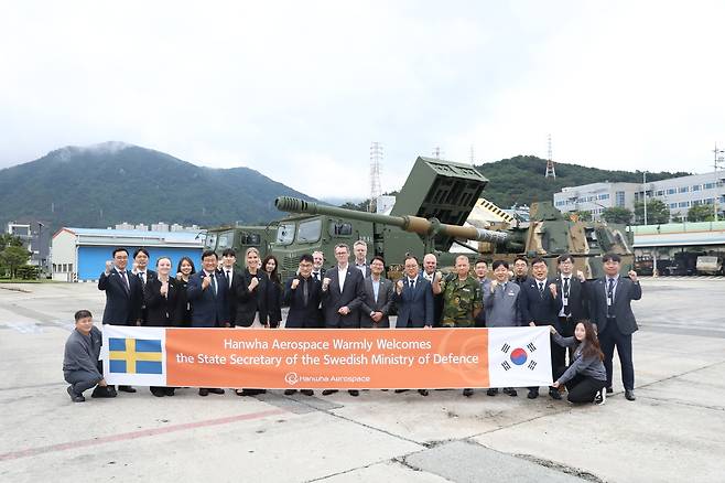 Peter Sandwall (center), Sweden's state secretary to the minister for defense, Swedish defense officials and Hanwha Aerospace executives pose for a photo in front of the K9 self-propelled howitzer during a visit to Hanwha Aerospace’s Changwon plant on Wednesday. (Hanwha Aerospace)