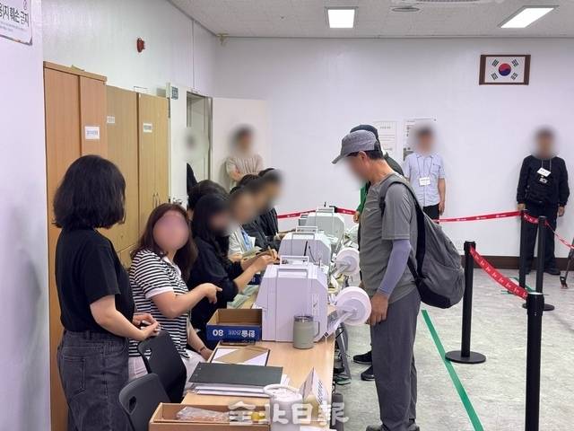29일 서신동 주민센터에서 투표관리원들이 유권자들에게 투표용지를 발급해 주고 있다. /이상구 기자