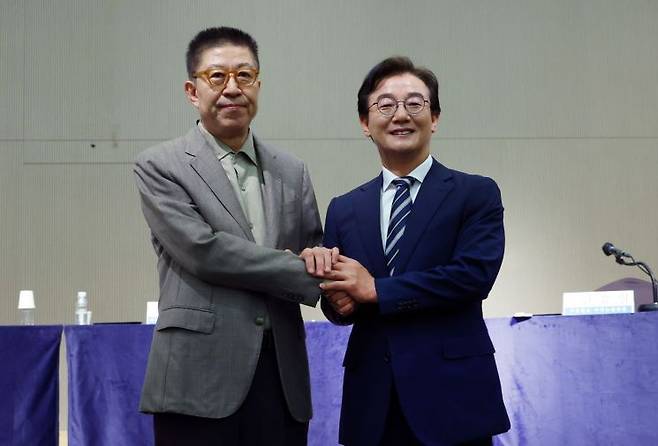 더불어민주당 전재수 부산시장 후보와 국민의힘 박형준 부산시장 후보가 지난 26일 관훈클럽·부산일보 주최 관훈토론회에서 손을 맞잡고 있다. [이미지출처=연합뉴스]