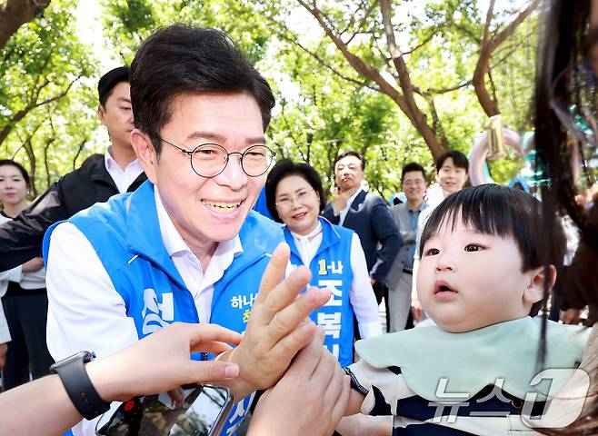 정원오 더불어민주당 서울시장 후보가 30일 서울 성동구 서울숲을 찾아 아기와 인사를 나누고 있다. 2026.5.30 ⓒ 뉴스1 이호윤 기자