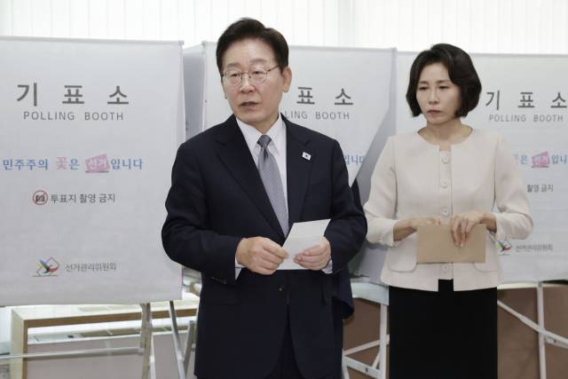 이재명 대통령이 제9회 전국동시지방선거 사전투표 첫날인 29일 서울 종로구 삼청동 주민센터에서 사전 투표 중 기표 도장 관련 문의를 하고 있다. 연합뉴스