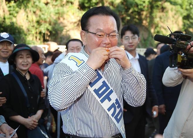 김부겸 더불어민주당 대구시장 후보가 31일 오전 대구 중구 달성공원 새벽시장을 찾아 시식용 오렌지를 맛보고 있다. 대구=뉴스1
