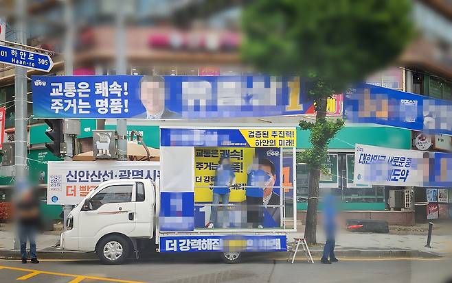 광명시 하안사거리 내 우회로 구간에 정차한 유세 차량과 낮게 설치된 선거 현수막이 뒤엉켜 있어 우회전 차량의 시야에 횡단보도 대기자가 보이지 않는 모습. 한준호기자