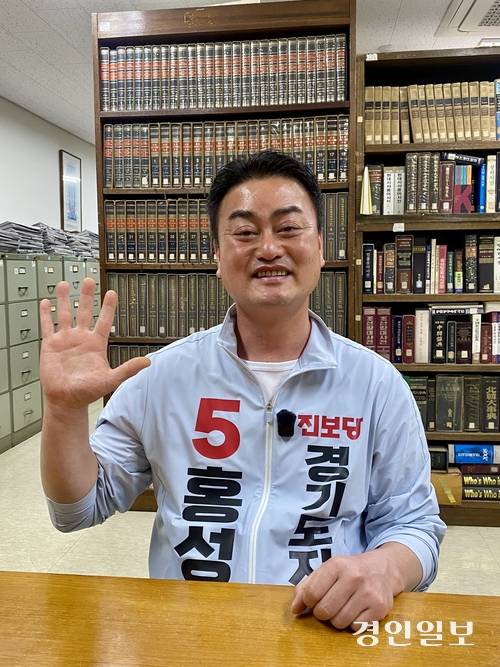 홍성규 진보당 경기도지사 후보가 자신의 기호인 ‘5’를 손으로 나타내고 있다. 2026.5.31 /강기정기자 kanggj@kyeongin.com