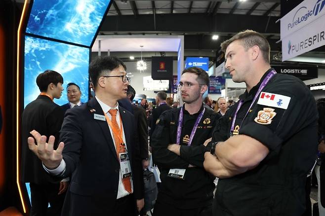 한화오션 관계자가 캐나다 오타와에서 열린 'CANSEC 2026' 전시회 내 한화오션 부스에서 방문객들에게 최신예 잠수함인 KSS-III 모델을 소개하고 있다. 사진=한화오션 제공