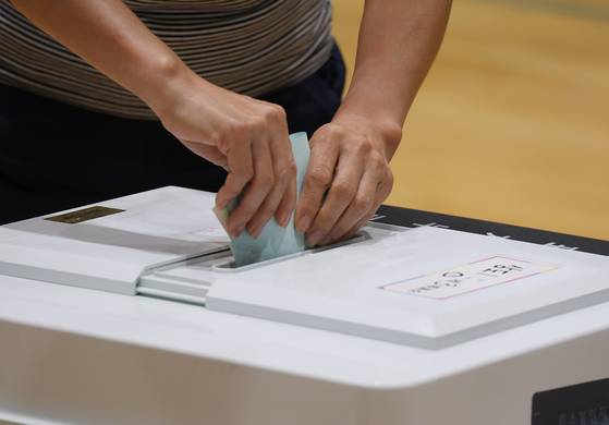 제9회 전국동시지방선거일인 3일 오전 제주시 중앙초등학교에 마련된 삼도1동 제3투표소에서 한 유권자가 투표함에 기표한 투표용지를 넣고 있다. 〈사진=연합뉴스〉