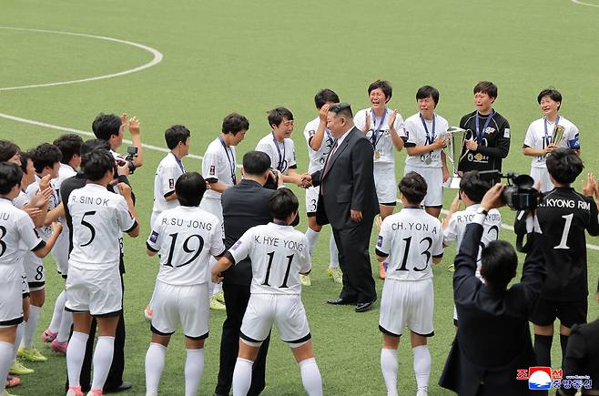 김정은 북한 국무위원장이 지난 1일 노동당 중앙간부학교 창립 80주년 기념행사에서 2025-2026 AFC 여자 챔피언스리그(AWCL)에서 우승한 내고향팀 선수들이 우승컵을 들고 환호하는 가운데 선수와 악수하며 격려하고 있다. <저작권자(c) 연합뉴스, 무단 전재-재배포, AI 학습 및 활용 금지>