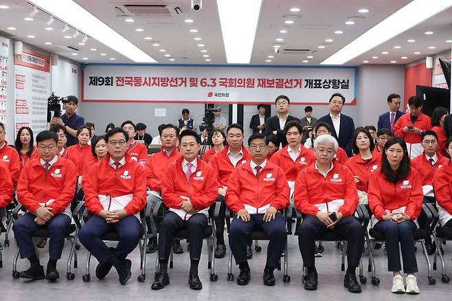 장동혁 국민의힘 대표(앞줄 왼쪽 세번째)가 주요 당직자들과 함께 서울 여의도 중앙당사에서 출구조사 결과 방송을 기다리고 있다. 뉴시스