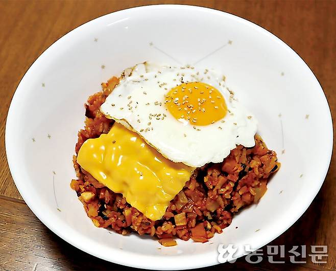 슬라이스치즈 한장과 달걀프라이를 올린 김치볶음밥.
