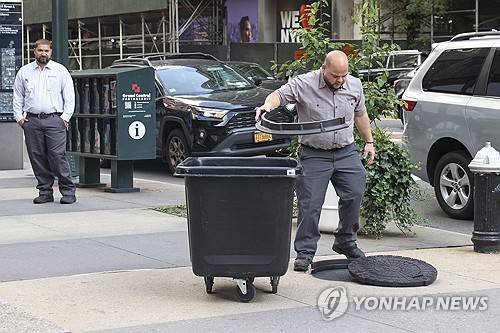 뉴욕시 맨홀 (뉴욕 EPA=연합뉴스) 2025년 7월 23일 미국 뉴욕주 뉴욕시의 세컨드 애비뉴와 42번가 교차로 근처에서 한 경비원이 프랑스 거리예술가 제임스 콜로미나가 설치했던 작품을 철거하고 있다. 이 작품은 도널드 트럼프 미국 대통령이 맨홀에서 나오는 모습을 묘사했다.  [기사 내용과 무관한 자료사진] 2026.6.3.