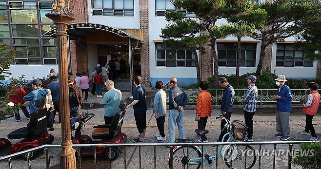 투표 시작 전부터 늘어선 줄 (울산=연합뉴스) 김용태 기자 = 제9회 전국동시지방선거 및 국회의원 재·보궐선거일인 3일 울산 남구 달동제3투표소가 마련된 동평중학교 앞에 유권자들이 줄을 서서 투표가 시작되기를 기다리고 있다. 2026.6.3 yongtae@yna.co.kr