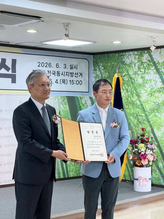 6·3 지방선거에서 울산시장에 당선된 더불어민주당 김상욱 당선인(오른쪽)이 4일 울산시선거관리위원회에서 당선증을 교부받고 있다. 김상욱 당선인 측 제공