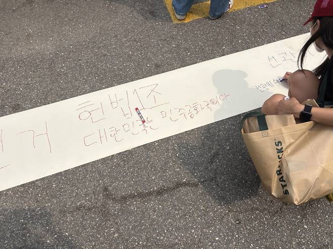 4일 서울 송파구 잠실 7동 제2투표소 앞에서 시위대가 '헌법 1조 대한민국은 민주공화국이다' 등의 문구를 적고 있따. (사진=권아인 수습기자)
