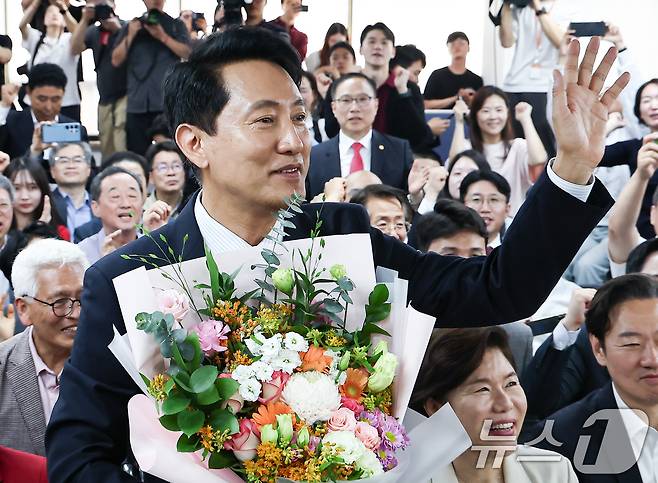 6·3 지방선거에서 당선된 오세훈 국민의힘 서울시장 후보가 4일 서울 종로구 선거사무소에서 꽃다발을 전달 받고 환호 하고 있다. 2026.6.4 ⓒ 뉴스1 김도우 기자