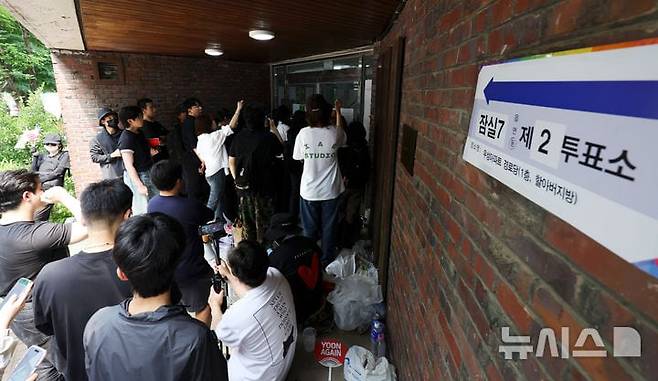 제9회 전국동시지방선거 및 국회의원 재·보궐선거 본투표일에 투표용지 부족으로 투표 시간이 오후 10시까지 연장됐던 서울 송파구 잠실7동 제2투표소 앞에 4일 새벽 투표용지 부족 사태에 항의하는 시민들이 모여 있다. /뉴시스