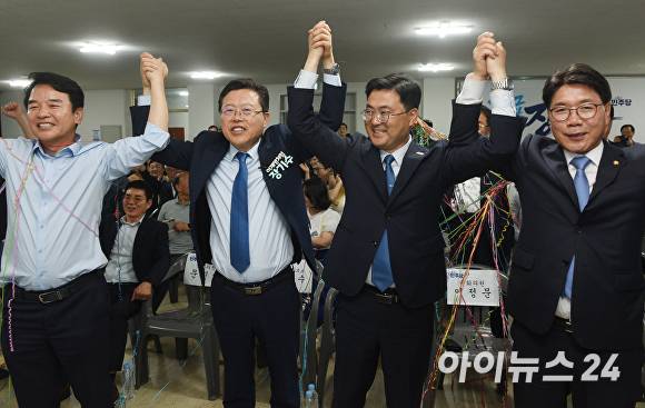 장기수 후보가 당선 유력해지자 문진석·이재관·이정문 국회의원과 함께 환호하고 있다  [사진=정종윤 기자]