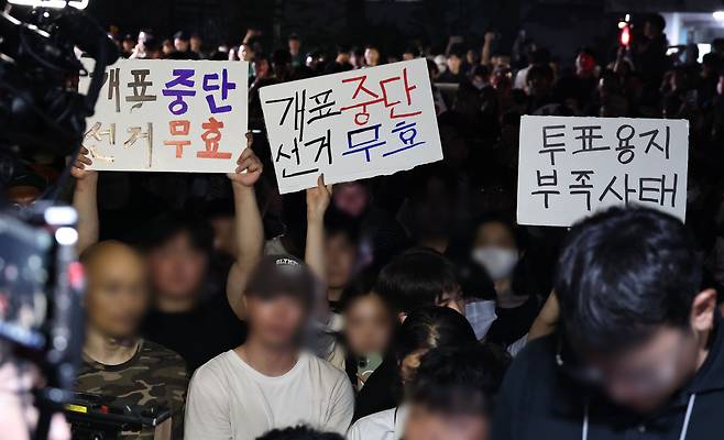 4일 제9회 전국동시지방선거 및 국회의원 재·보궐선거 투표용지 부족으로 투표 시간이 오후 10시까지 연장됐던 서울 송파구 잠실7동 제2투표소 앞에서 ‘부정선거’ 등 손팻말을 든 시민들이 구호를 외치고 있다. [연합]