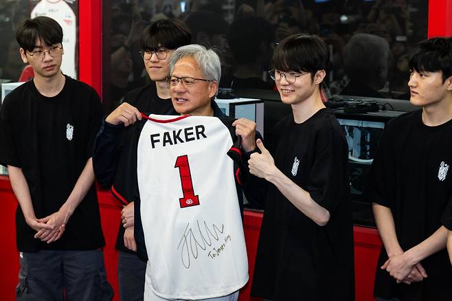 엔비디아 젠슨 황 최고경영자(CEO)가 5일 서울 마포구 T1베이스 캠프에서 '페이커' 이상혁을 비롯한 e스포츠 구단 T1의 리그 오브 레전드(LoL) 선수단을 만나 페이커'의 사인이 담긴 기념품을 선물 받고 있다. 연합뉴스