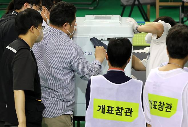 5일 전국동시지방선거 송파구 개표소인 서울 송파구 올림픽공원 핸드볼경기장에서 관계자들이 6·3 지방선거 투표용지 부족 사태를 겪은 잠실7동 제2투표소 투표함 특수봉인지를 뜯고 있다.사진=뉴시스